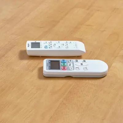 two remote controls sitting on top of a wooden table at Y's INN Oyama 021T in Tokyo