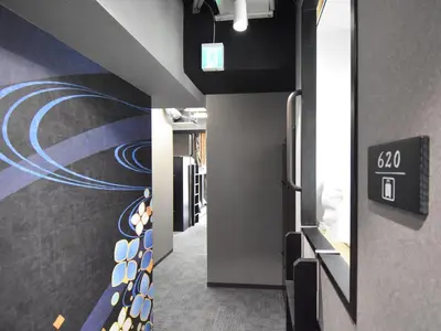 a hallway with a painting on the wall at HOTEL WINDS ASAKUSA Capsule Inn \u6d45\u8349 in Tokyo