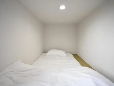 a small white room with a bed in it at HOTEL WINDS ASAKUSA Capsule Inn \u6d45\u8349 in Tokyo