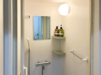 a bathroom with a sink and a mirror and a toilet at HOTEL WINDS ASAKUSA Capsule Inn \u6d45\u8349 in Tokyo