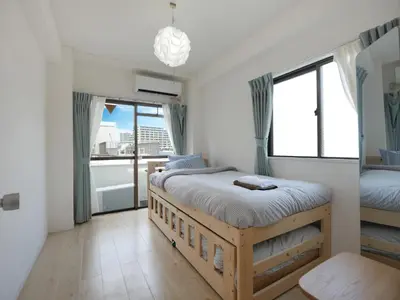 a bedroom with two beds and a balcony at CasaN 402 in Tokyo