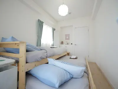 a room with four bunk beds with blue pillows at CasaN 402 in Tokyo
