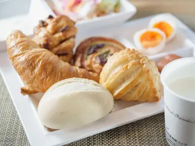 a plate of pastries and croissants on a table at Super Hotel Tokyo JR Kamata Nishiguchi in Tokyo