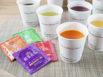 a table with four cups of tea and a bag at Super Hotel Tokyo JR Kamata Nishiguchi in Tokyo