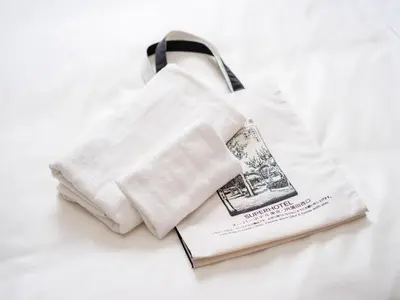 a white towel and a book on a bed at Super Hotel Tokyo JR Kamata Nishiguchi in Tokyo