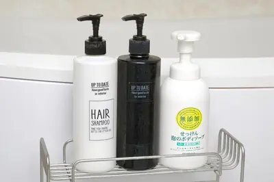 a shelf with three bottles of hair products on it at Zuzu & Gizmo in Tokyo