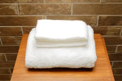 two white towels sitting on a wooden cutting board at Zuzu & Gizmo in Tokyo
