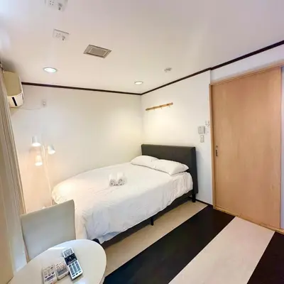 a small room with a bed and a table at ookubo hills Room for 2 located in Shinjuku area in Tokyo