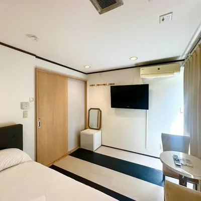 a hotel room with a bed and a flat screen tv at ookubo hills Room for 2 located in Shinjuku area in Tokyo