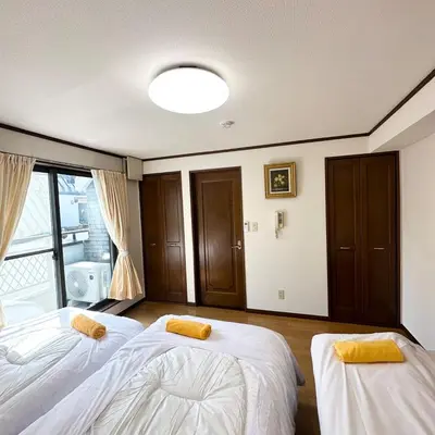 two beds in a room with a window at ookubo hills Unique 3 Bedroom House in Shinjuku area in Tokyo