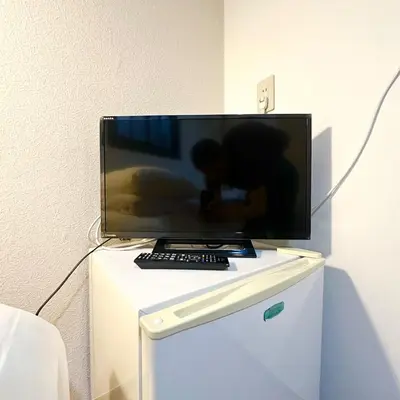 a flat screen tv sitting on top of a white cabinet at ookubo hills Room for 1 located in Shinjuku area in Tokyo
