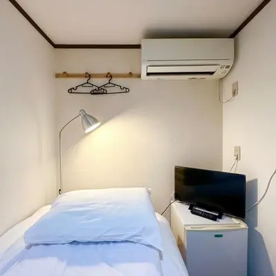 a bedroom with a bed and a tv and a lamp at ookubo hills Room for 1 located in Shinjuku area in Tokyo
