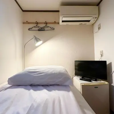 a bedroom with a bed and a tv and a lamp at ookubo hills Room for 1 located in Shinjuku area in Tokyo