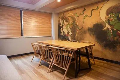a table and chairs in a room with a painting at Asakusa Premium Stay \u5f69-Irodori- in Tokyo
