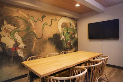 a conference room with a table and a large painting on the wall at Asakusa Premium Stay \u5f69-Irodori- in Tokyo