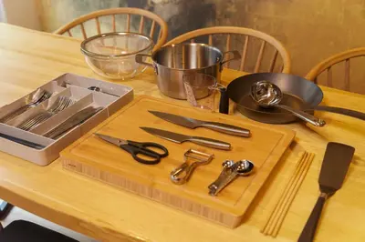 a wooden table with a cutting board with utensils on it at Asakusa Premium Stay \u5f69-Irodori- in Tokyo