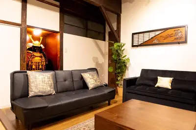 a living room with a black couch and a table at The Guest House Nagomi in Tokyo
