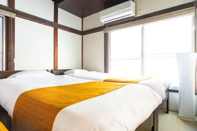 a bedroom with two beds and a large window at The Guest House Nagomi in Tokyo