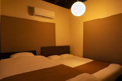 a bedroom with two beds and a large window at The Guest House Nagomi in Tokyo
