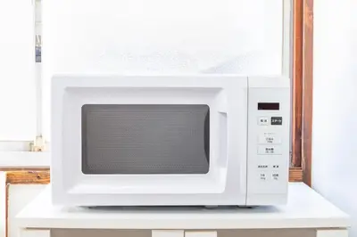 a microwave oven sitting on top of a white cabinet at The Guest House Nagomi in Tokyo