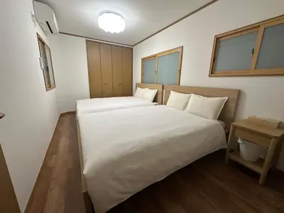 a bedroom with two beds with white sheets at \u6d77\u5bb9\u7acb\u77f3 in Tokyo