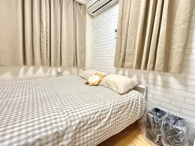 a teddy bear laying on a bed in a bedroom at Shinjuku Cloudlive AE AF in Tokyo