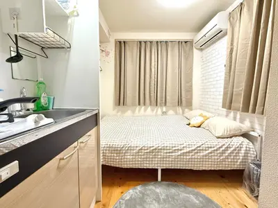 a small room with a bed and a sink at Shinjuku Cloudlive AE AF in Tokyo