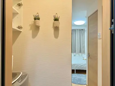 a bathroom with a sink and two baskets with flowers on the wall at Shinjuku Cloudlive AE AF in Tokyo