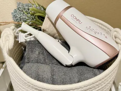 a white hair dryer sitting in a basket at Shinjuku Cloudlive AE AF in Tokyo