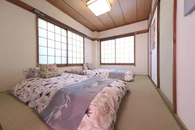 a bedroom with two beds and two windows at Lucky house west Kitasenju in Tokyo