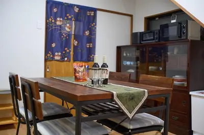 a dining room table with two wine glasses on it at Lucky house west Kitasenju in Tokyo