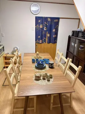 a wooden dining room table with chairs and a clock at Lucky house west Kitasenju in Tokyo