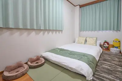 a bedroom with a bed and a large window at Lucky house west Kitasenju in Tokyo