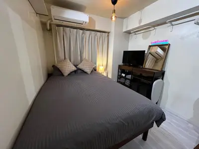 a small bedroom with a bed and a television at SHINJUKU station 10min by walk! KB House in Tokyo