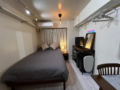 a bedroom with a bed and a television and a desk at SHINJUKU station 10min by walk! KB House in Tokyo
