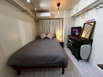 a bedroom with a bed and a mirror and a television at SHINJUKU station 10min by walk! KB House in Tokyo
