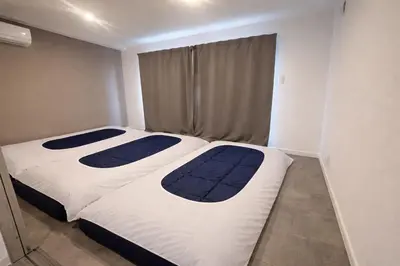 two beds in a small room withthritisthritis at COTO Shibuya Premium Garden in Tokyo
