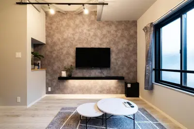 a living room with two white tables and a flat screen tv at Eims stay Ikebukuro in Tokyo