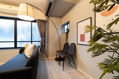 a living room with a couch and a chair at Eims stay Ikebukuro in Tokyo