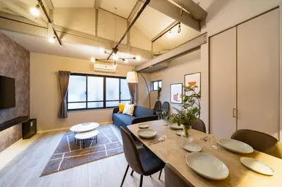 a living room with a table and chairs and a couch at Eims stay Ikebukuro in Tokyo