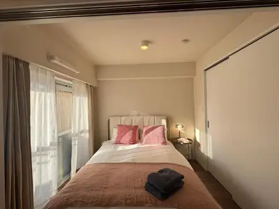a bedroom with a bed with pink pillows and a window at Kabukicho-13F-SJ0019 in Tokyo