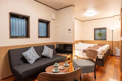 a living room with a couch and a bed at Nestry \u6d45\u8349 yuuan Sakura102 in Tokyo