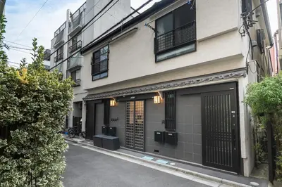 a building with black doors and windows on a street at Nestry \u6d45\u8349 yuuan Sakura102 in Tokyo