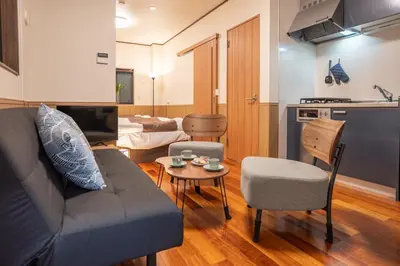 a living room with a couch and a table at Nestry \u6d45\u8349 yuuan Sakura102 in Tokyo