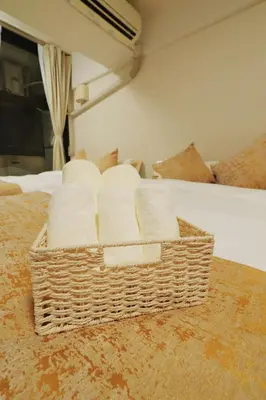 a pile of towels in a basket on a bed at F-Mansion209 in Tokyo