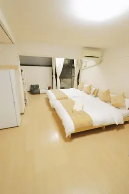 a bedroom with a large bed with white sheets and pillows at F-Mansion209 in Tokyo