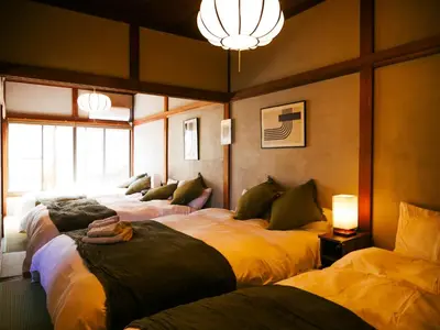 a room with four beds in it with a chandelier at MSTAY\u6771\u6c60\u888bone in Tokyo