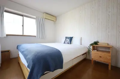 a bedroom with a large bed and a window at \u6e0b\u8c37\u9ad8\u7d1a\u4e00\u6238\u5efa\u3066 \u8cb8\u5207 \u30c6\u30e9\u30b9\u4ed8\u304d \u6700\u5927\u4e03\u540d in Tokyo
