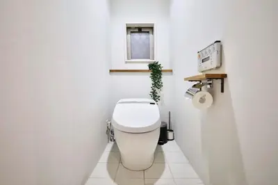 a white bathroom with a toilet with a window at \u6e0b\u8c37\u9ad8\u7d1a\u4e00\u6238\u5efa\u3066 \u8cb8\u5207 \u30c6\u30e9\u30b9\u4ed8\u304d \u6700\u5927\u4e03\u540d in Tokyo