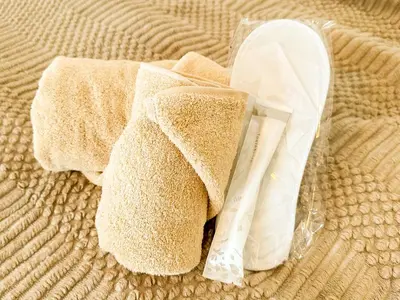 a towel and a plastic bag on a bed at Syforme Keikyu-Kamata Residence in Tokyo